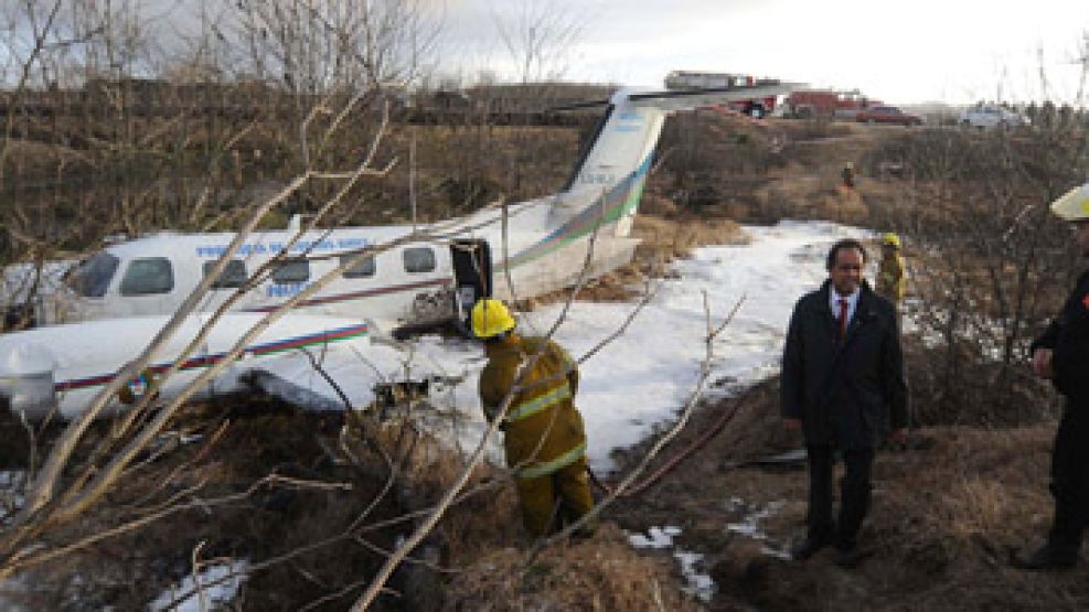 El gobernador Scioli observa el avión accidentado.
