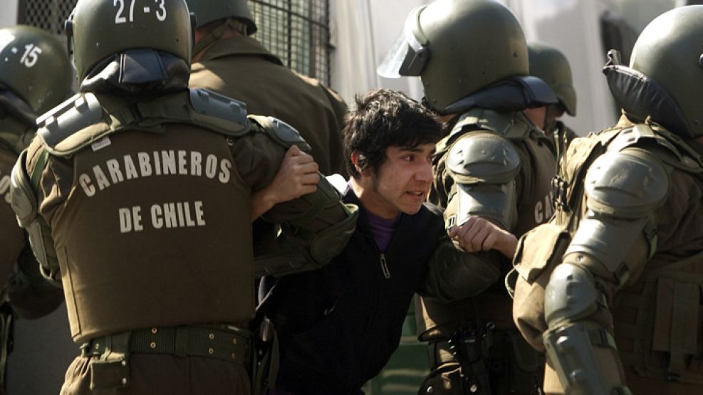 Policías detienen a un estudiante chileno durante una marcha nacional convocada para "frenar la agenda privatizadora del Gobierno" de Piñera en la educación.