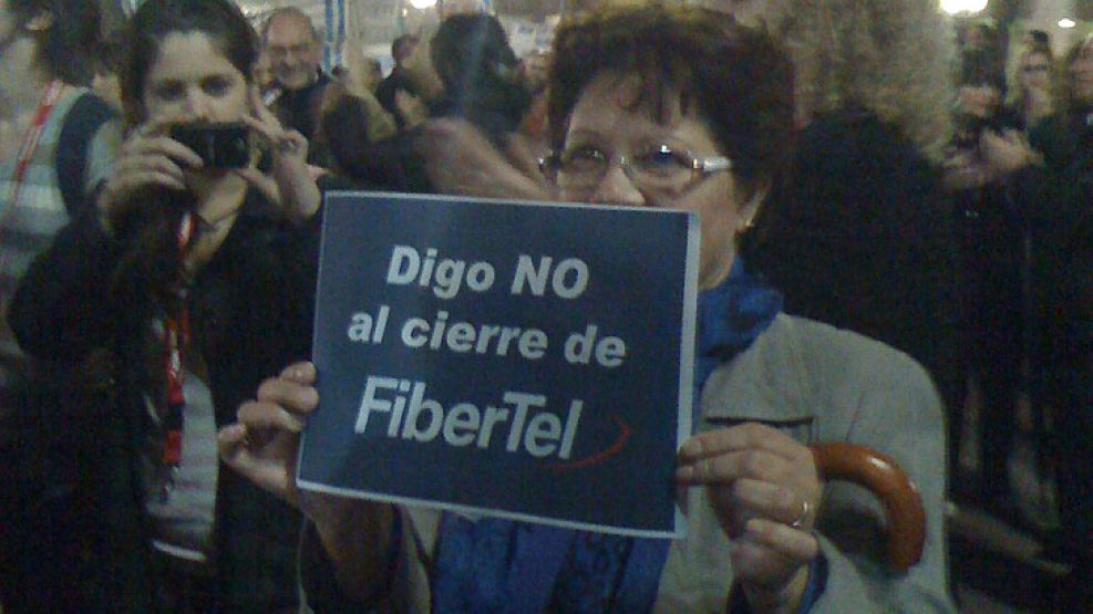 Una usuaria del servicio de Internet de Fibertel muestra su cartel en defensa a la empresa.