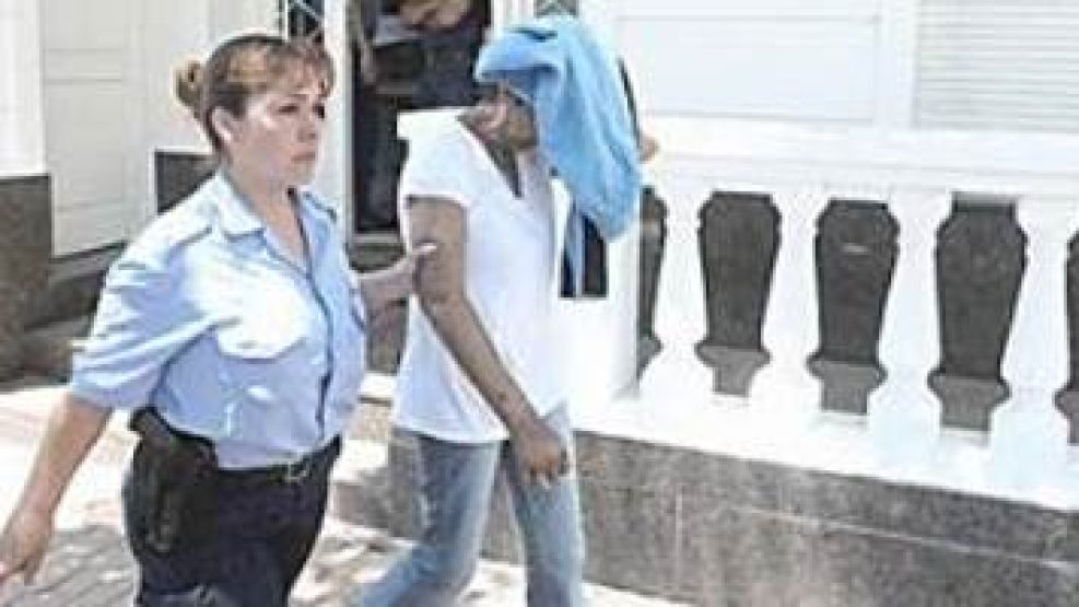 La mujer que pescaron 'in fraganti' es llevada por una agente policial.