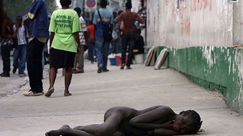 Tremenda imagen: una mujer enferma de cólera tirada en plena calle, frente al colapsado Hospital General, en Puerto Príncipe.