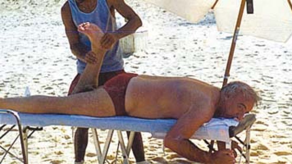 Roberto Fernández tomando un masaje en una playa.