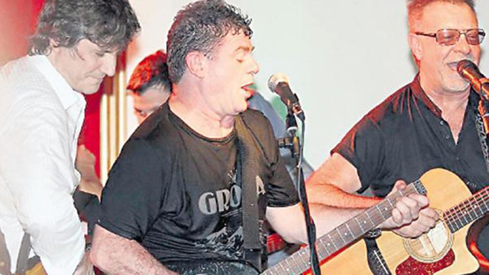 Amado Boudou tocando la guitarra junto a Santaolalla y León Gieco.