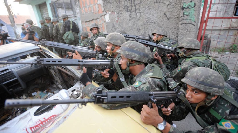 Soldados del Ejército brasileño apuntan sus armas hoy en la favela Grota en Río de Janeiro.