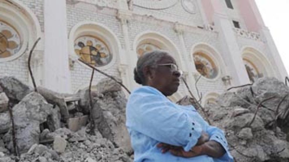 Una mujer en Puerto Príncipe frente a una iglesia que fue destruída por el sismo.