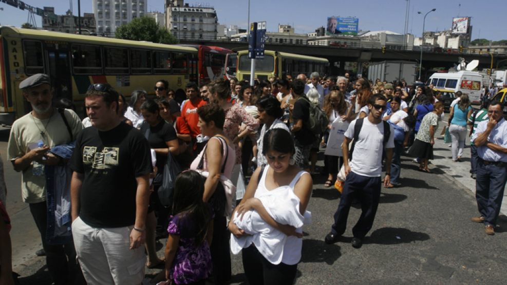 Los usuarios tratando de subirse a un colectivo por el parto dispuesto por los ferroviarios