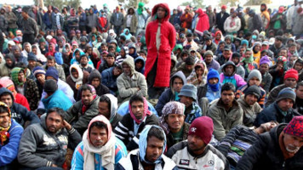 Trabajadores emigrantes de Libia, descansan en el campo de refugiados instalado junto a la frontera de Ras el Jedir (Túnez)