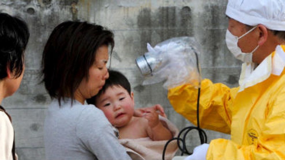 Personal médico comprueba los niveles de radiación de una mujer y su hijo en Kawamata en la región de Fukushima.