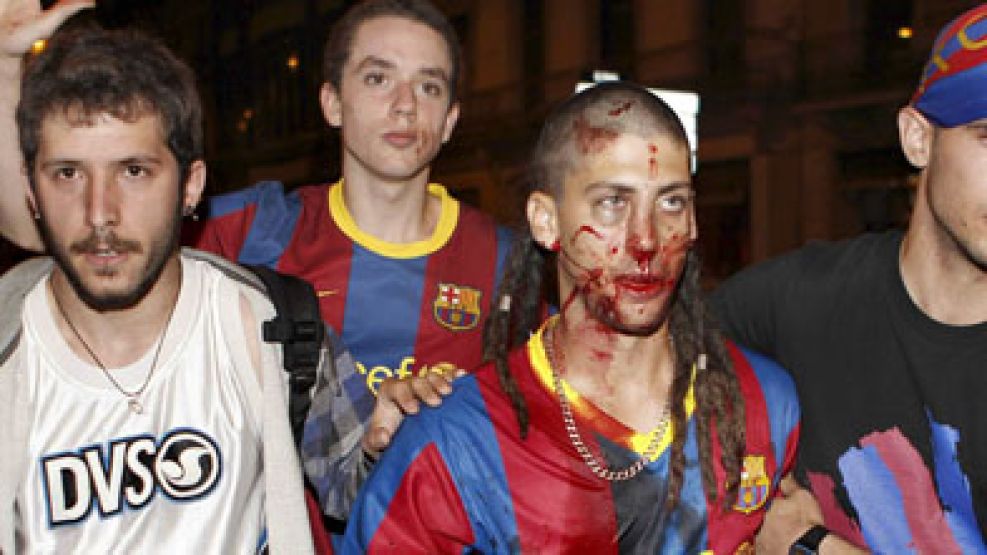 Un joven ensangrentado es llevado por otros hinchas del Barcelona.