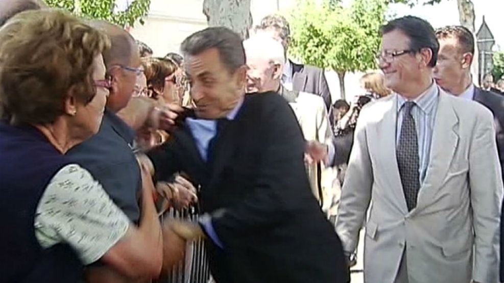 Captura de TV. El presidente francés Nicolas Sarkozy es tironeado en un intento de ataque en el sur de Francia.