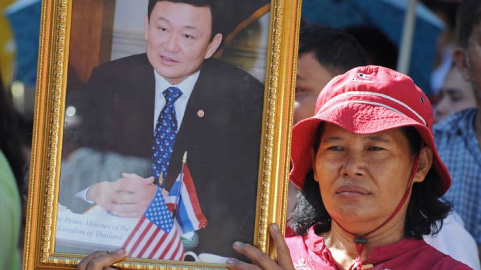 Una mujer con un retrato de Thaksin Shinawatra. Su hermana, Thaksin Shinawatra, es la nueva mandataria de Tailandia.