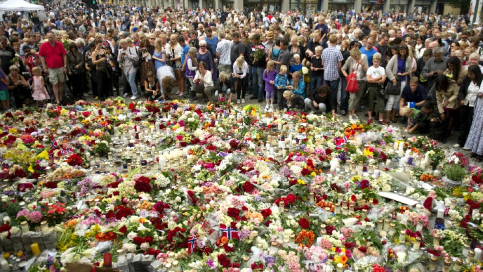 Noruega. La gente se reúne frente al tributo floral dedicado a las víctimas del coche bomba y del tiroteo.