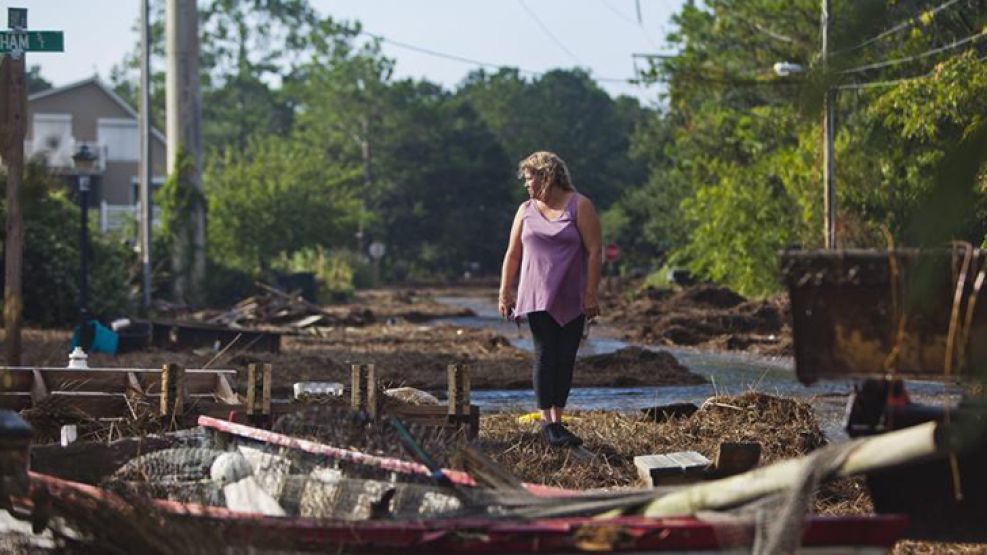 Una mujer entre palos de luz y caminos rotos en Kitty Hawk, cerca de la Costa Este de Estados Unidos.