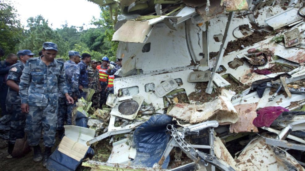 La policía nepalesa inspecciona los restos de un avión de la aerolínea Buddha Air tras estrellarse en la localidad de Kotdanda, cerca de Katmandú (Nepal).