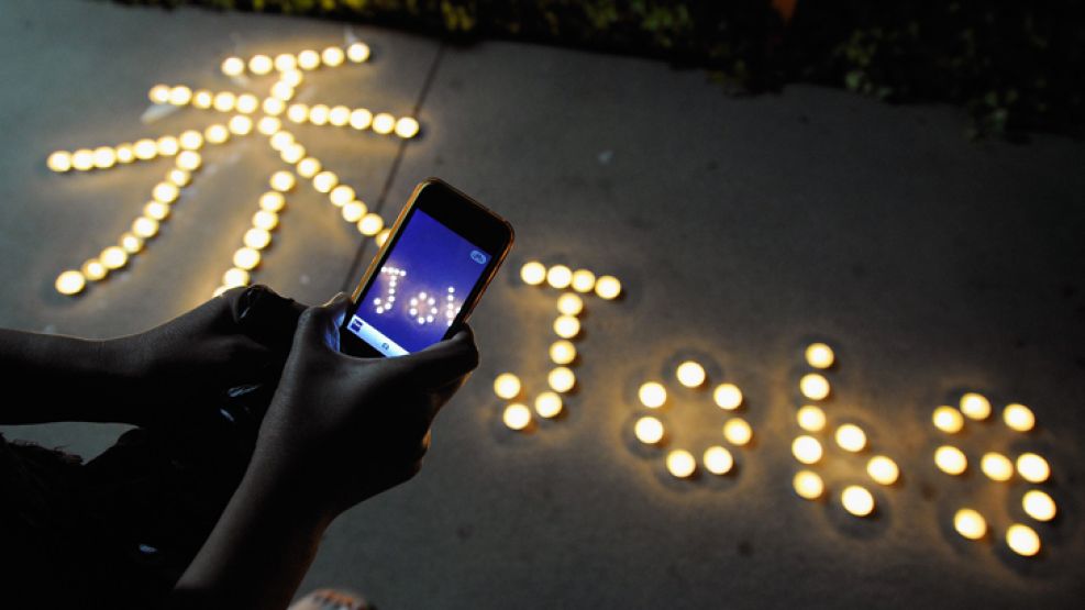 Un grupo de estudiantes chinos rinde homenaje al fundador de Apple con velas.