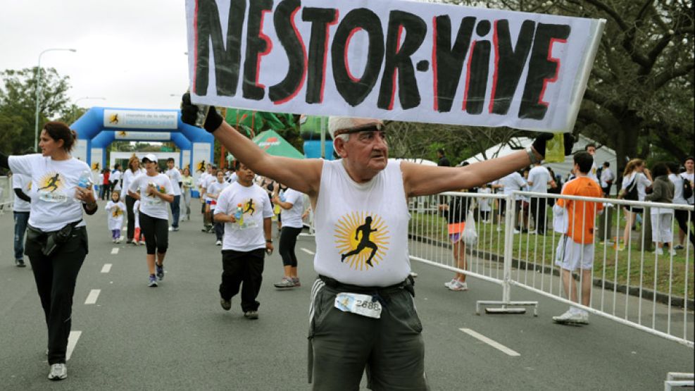 Un participante de la "Maratón de la Alegría Néstor Kirchner" levanta un cartel recordatorio del ex Presidente de la Nación.