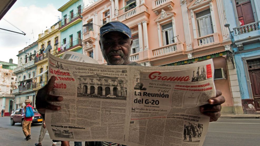 Un ciudadano cubano lee el diario "Granma" con los nuevos anuncios sobre la propiedad privada.