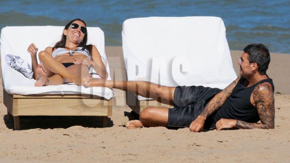 La pareja ríe y se divierte en la playa desierta.