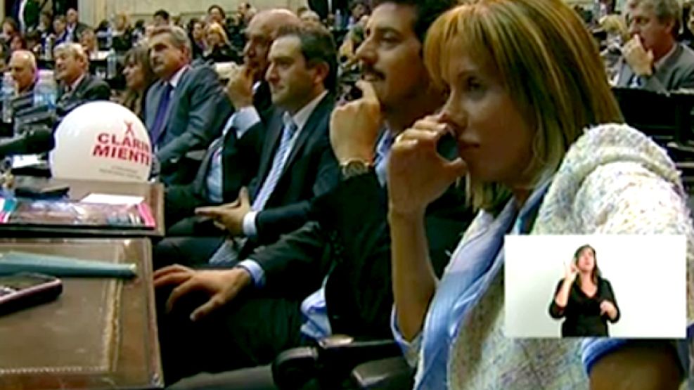 Larroque con el globo de "Clarín miente" mientras escucha a CFK en el Congreso.