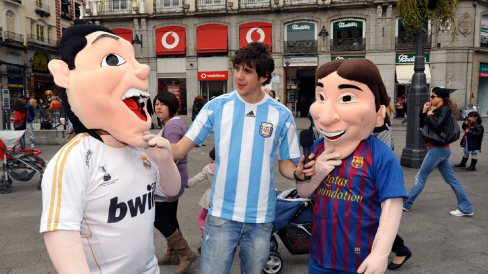 Festejos previos al partido de un madridista disfrazado de Cristiano Ronaldo y otro como Messi, junto a Alan un encuestador.