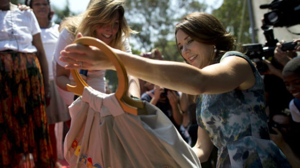 La princesa recibe una cartera hecha por los habitantes de la favela.