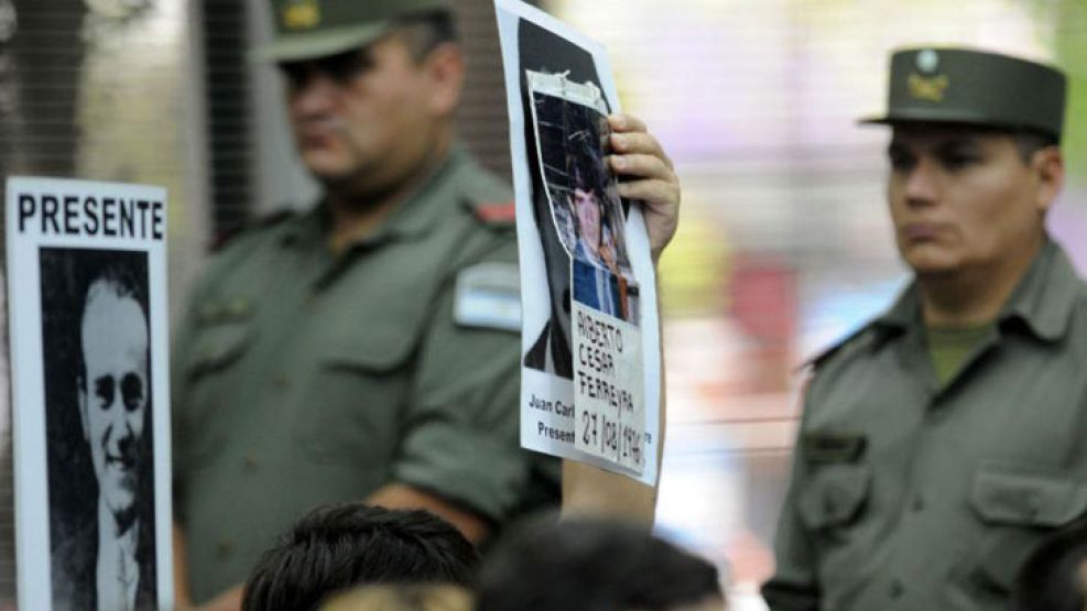 El primer día del juicio. Familiares de desaparecidos levantan las imágenes de sus familiares dentro de la sala.