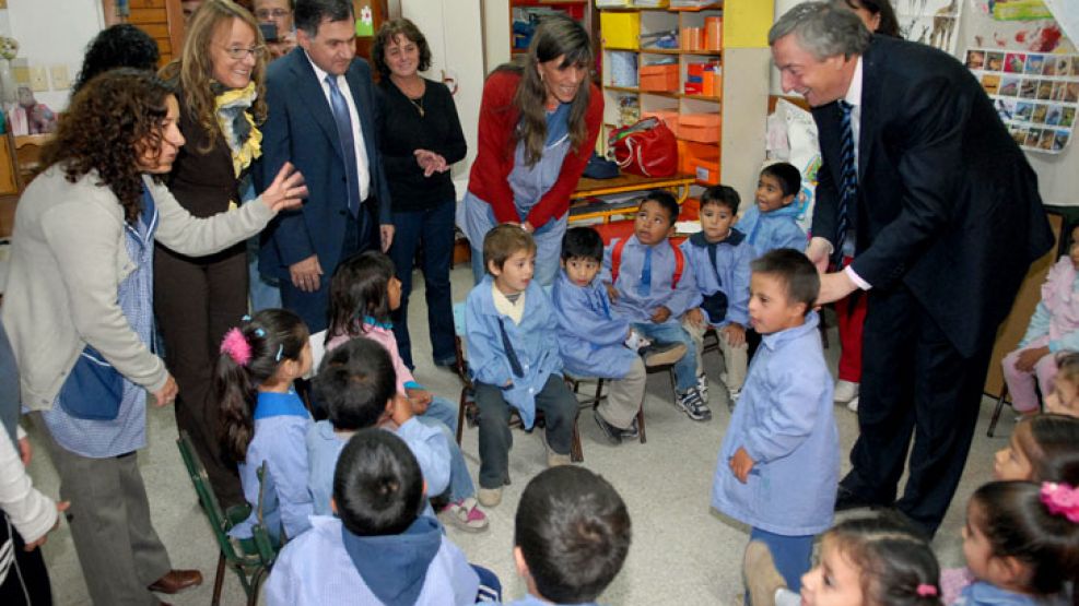 Néstor Kirchner con niños de una escuela. Quieren que su nombre aparezca en todos lados.