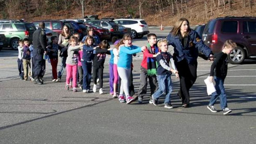 Los niños fueron evacuados de la escuela caminando en fila por oficiales de policía.