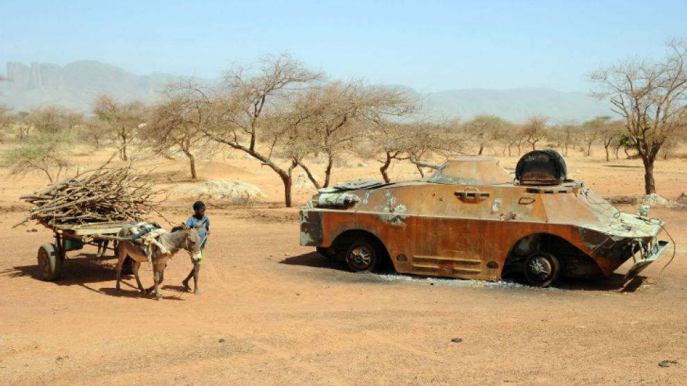 Un niño pasa con su carro de madera tirado por un burro junto a un tanque de la ejército maliense en la ciudad de Douentza.
