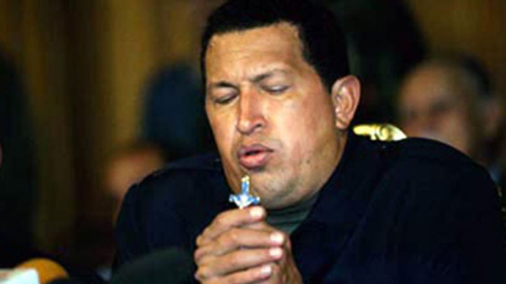 Chávez besa la cruz. Siempre se declaró cristiano.