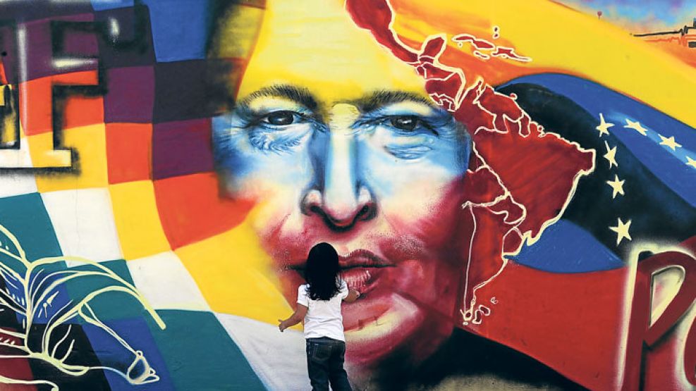 Omnipresencia. Una niña delante de una pared de Caracas pintada con la cara del ex presidente.