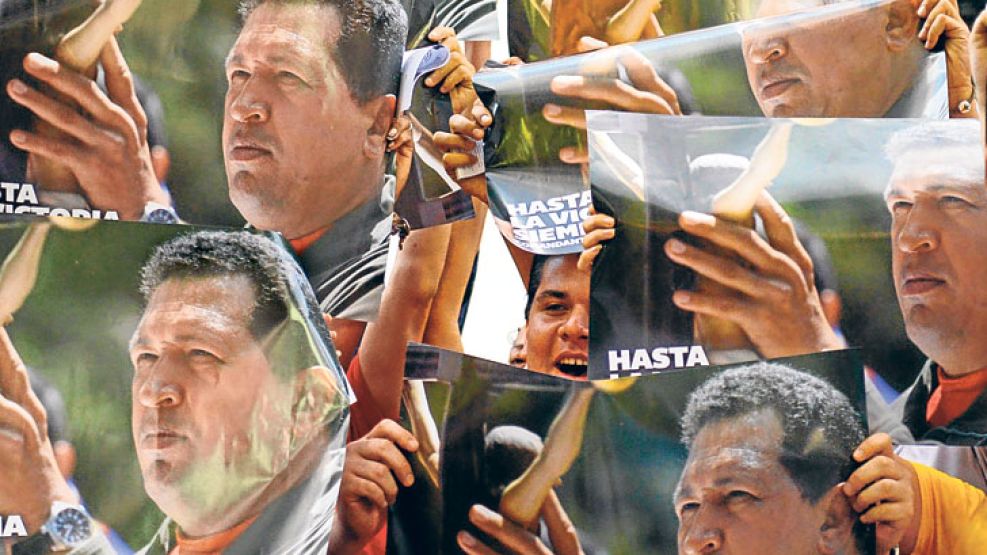 Chávez siempre esta. En un acto de Maduro, chavistas muestran fotos del ex presidente junto a una imagen de Jesucristo.