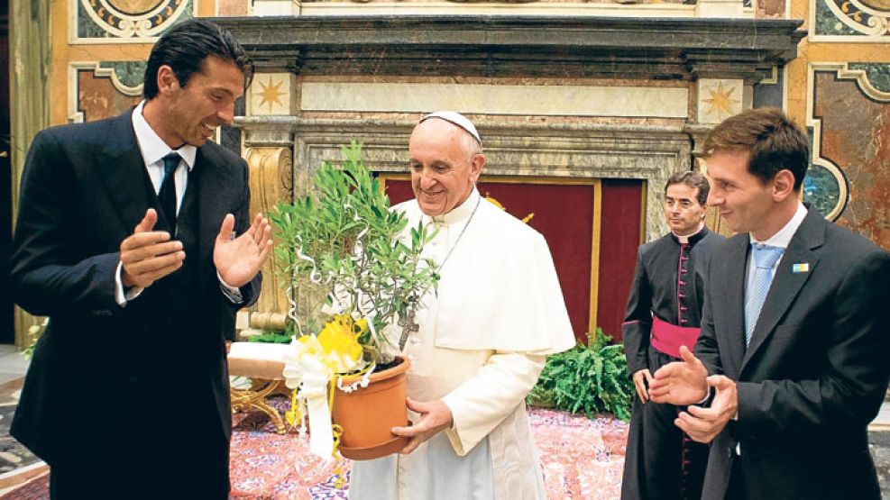 Regalo. Francisco rodeado por Gianluigi Buffon, arquero de la selección italiana, y Messi, quien le entregó el árbol de olivo que el pontífice sostiene. 