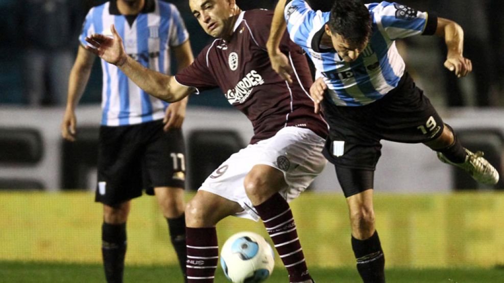 Lucha de titanes. Silva trata de cubrir la pelota ante Ortiz, luego expulsado. Pena en Avellaneda.