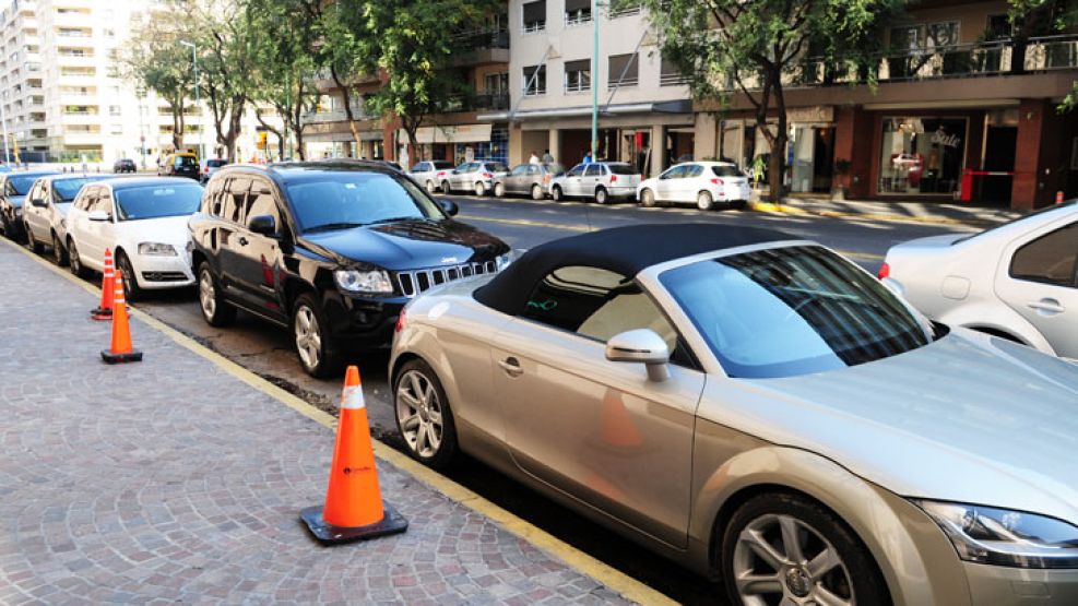 Infracción. En Puerto Madero, una línea de automóviles estacionados sobre la línea amarilla. La grúa, en acción.