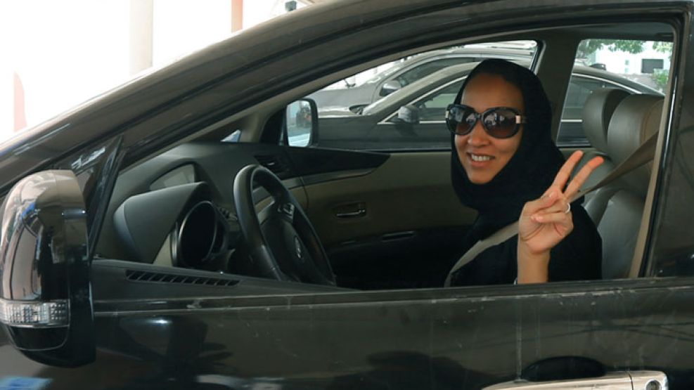 Liberacion. Con un hiyab, una mujer saluda frente al volante.