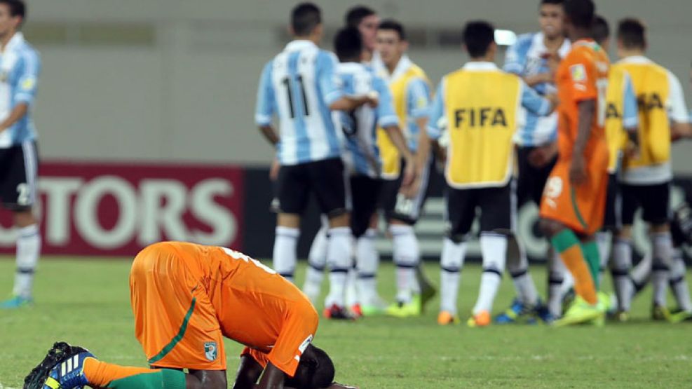 Contraste. El partido ya es historia, y un marfileño lo sufre. Atrás el equipo de Grondona, campeón sudamericano, que ahora va por el título mundial.