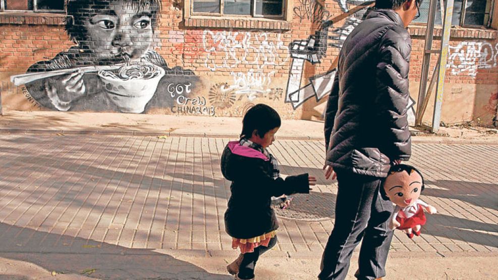Nueva era. Una mujer camina con su hijo en Beijing.