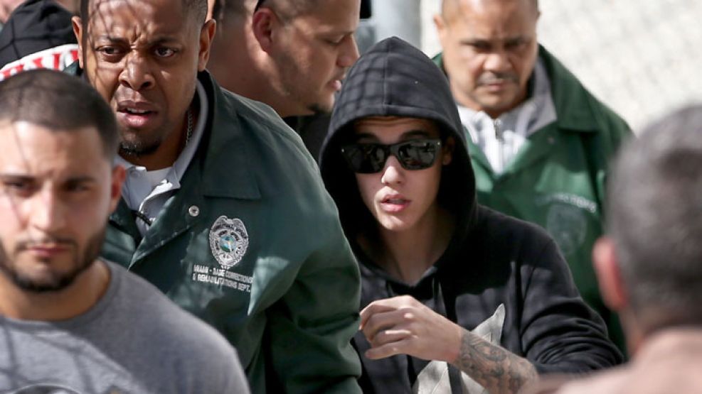Protegido. Por guardaespaldas y con lentes y capucha, Justin dejó la cárcel de Miami, donde pasó una noche luego de ser detenido.