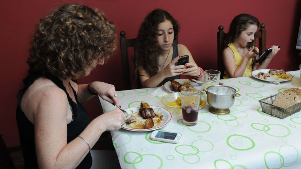 Mala compañia. El uso del celular a la hora de comer se asocia con una menor comunicación familiar pero también con una mala alimentación y sobrepeso.