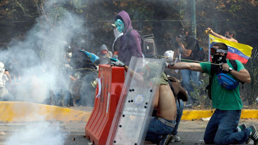 Choques. Manifestantes antichavistas arrojaron piedras contra los militares el martes en Caracas.