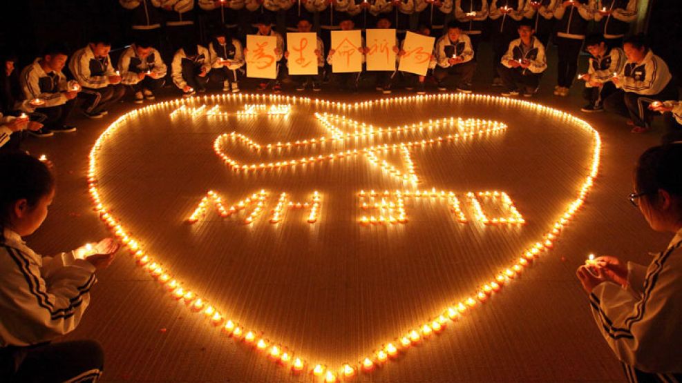 Mensaje. Niños de una escuela china encienden velas para el vuelo MH370, que desapareció hace una semana sin dejar rastros.