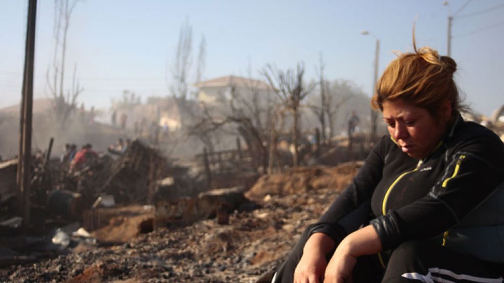 Desolacion. Una vecina de los cerros arrasados por el fuego salvó su vida, pero perdió su casa, como otros tres mil chilenos.