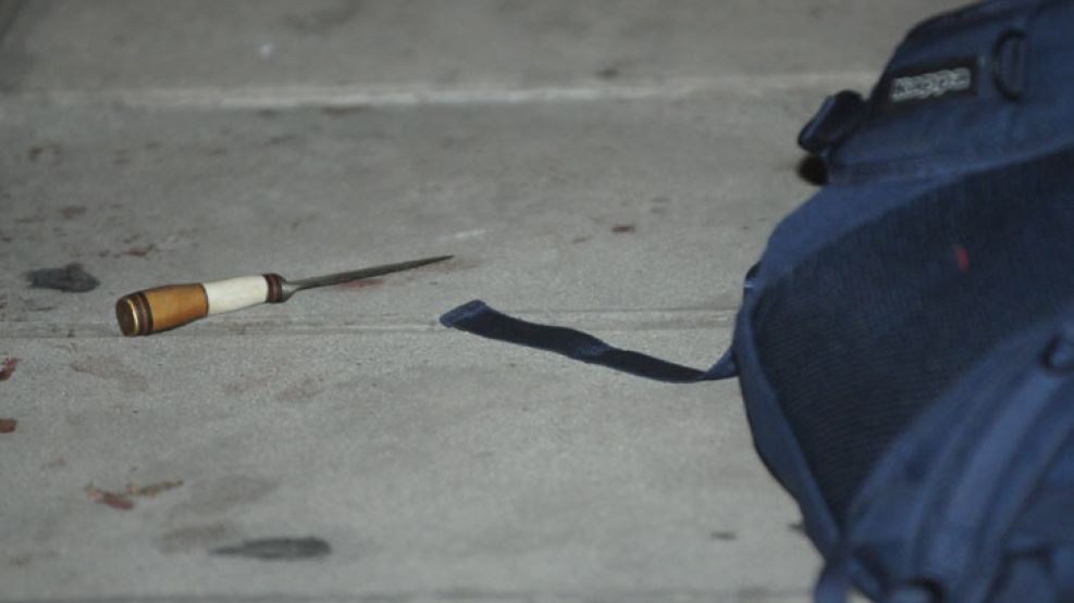 Evidencias. La mochila de la víctima quedó tirada en la vereda, junto al cuchillo con el que habría sido apuñalado.