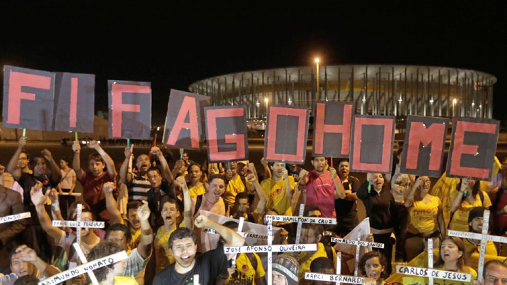 Repudio. Jóvenes alzaron esta semana su voz contra la FIFA. Exhibieron cruces con los nombres de los obreros muertos en las obras. La convocatoria, menor que en 2013.