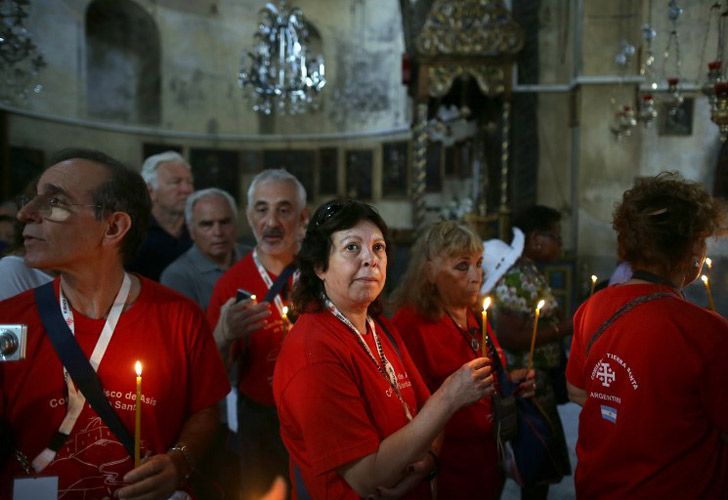 Peregrinos católicos esperan con velas para entrar a la Gruta en la Iglesia de Natividad, creída ser el lugar de nacimiento de Jesucristo, en Cisjordania de Belén.