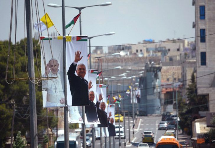 Banderolas con la imagen de Papa Francisco y el presidente palestino, Mahmud Abba,s en los postes de las farolas.