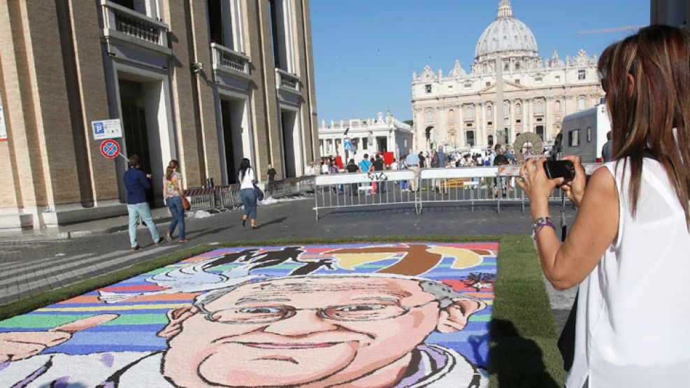 Pontífice. Una turista fotografía un retrato del Papa frente a la Plaza de San Pedro, en el Vaticano.