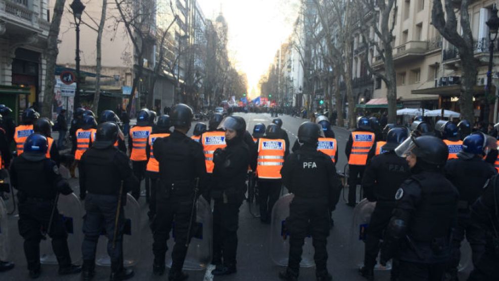 Una barrera de efectivos policiales se repliegan sobre Av. de Mayo para impedir el avance de una protesta.