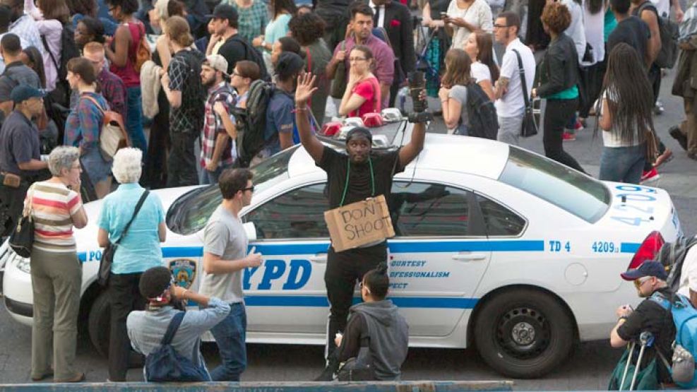 No disparen. Es la frase del joven que alza las manos, durante una protesta ayer en Nueva York.